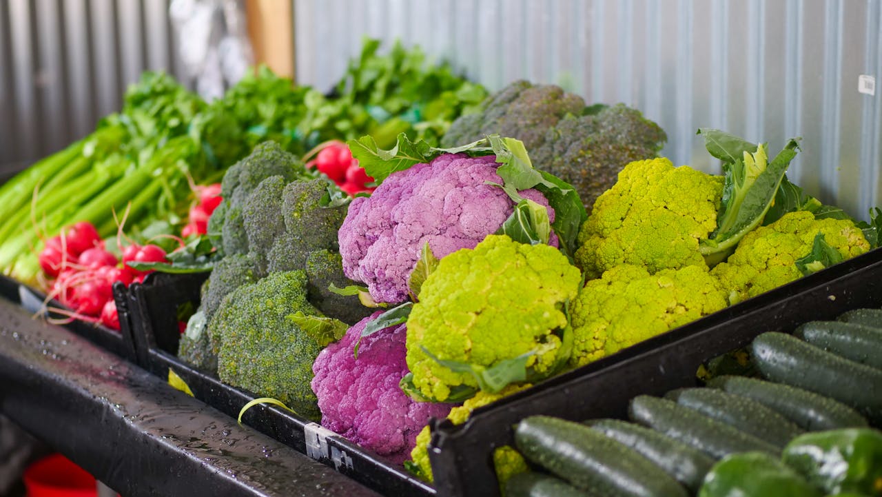 Vibrant display of organic vegetables including colorful cauliflower and radishes at a market.
